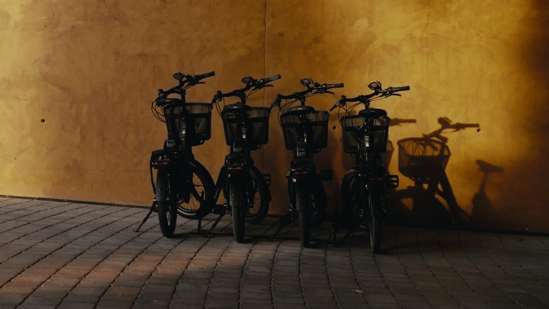 Four Kalkhoff e-bikes lined up against a golden wall